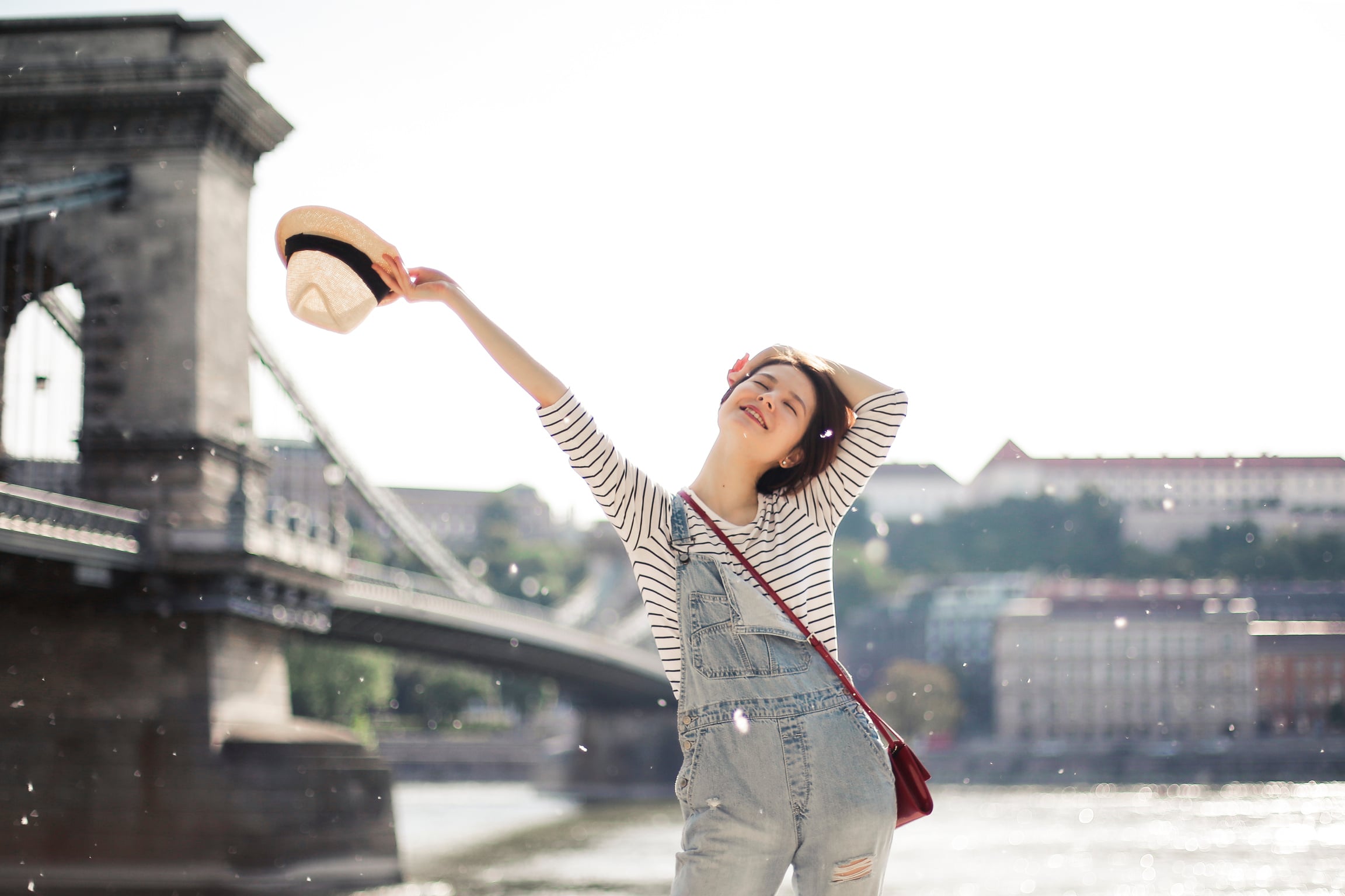 Happy woman on embankment near bridge